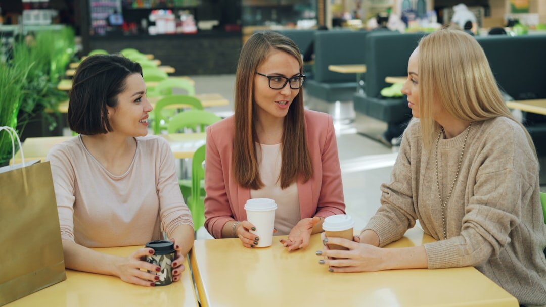 Small editorial team of three people discussing around a table